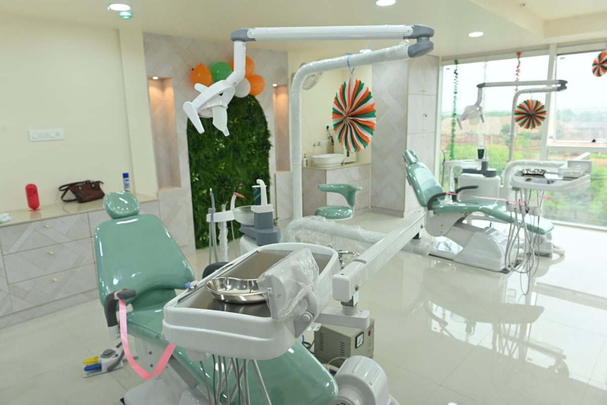 A Care32 dental chair and operating light, with the clinic's green living wall behind