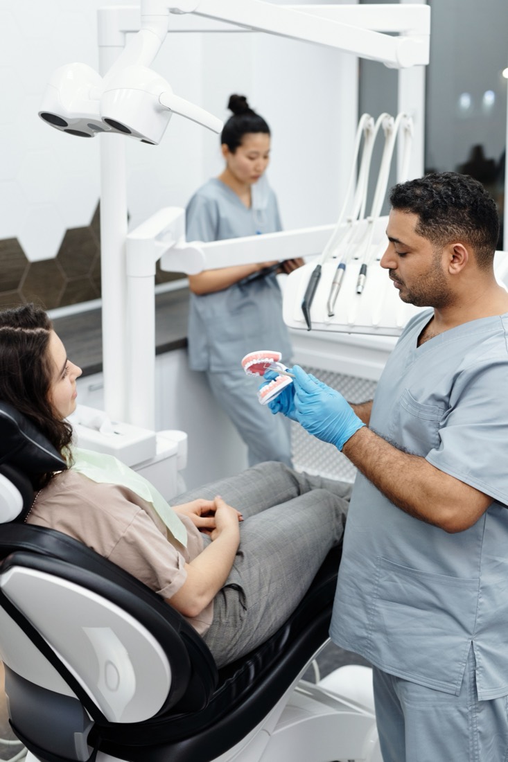 Dentist explaining treatment with a dental model at Care32