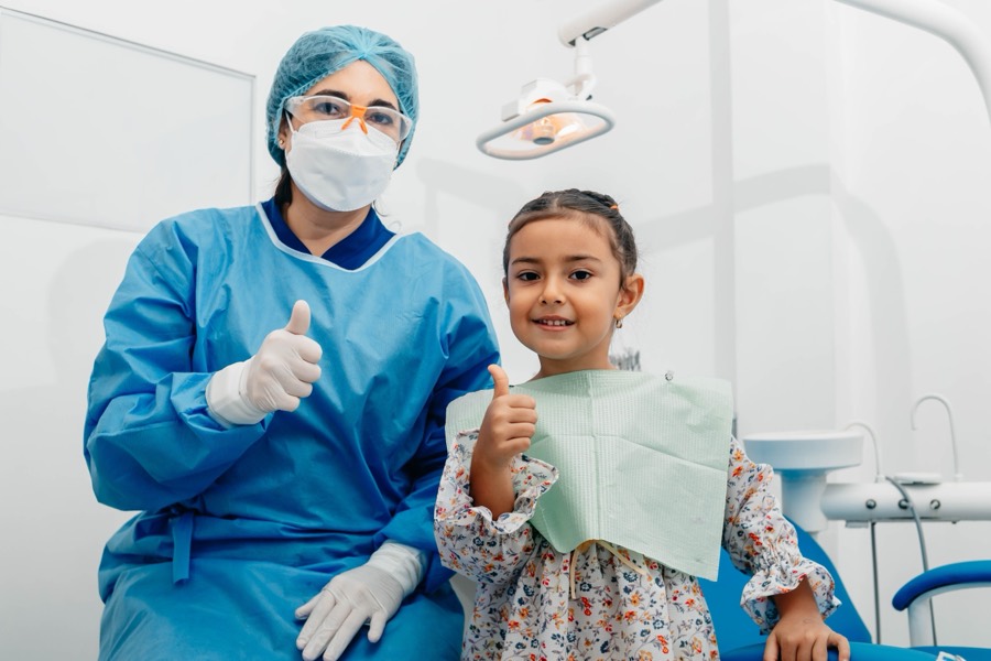 Child giving a thumbs-up after a gentle dental visit at Care32