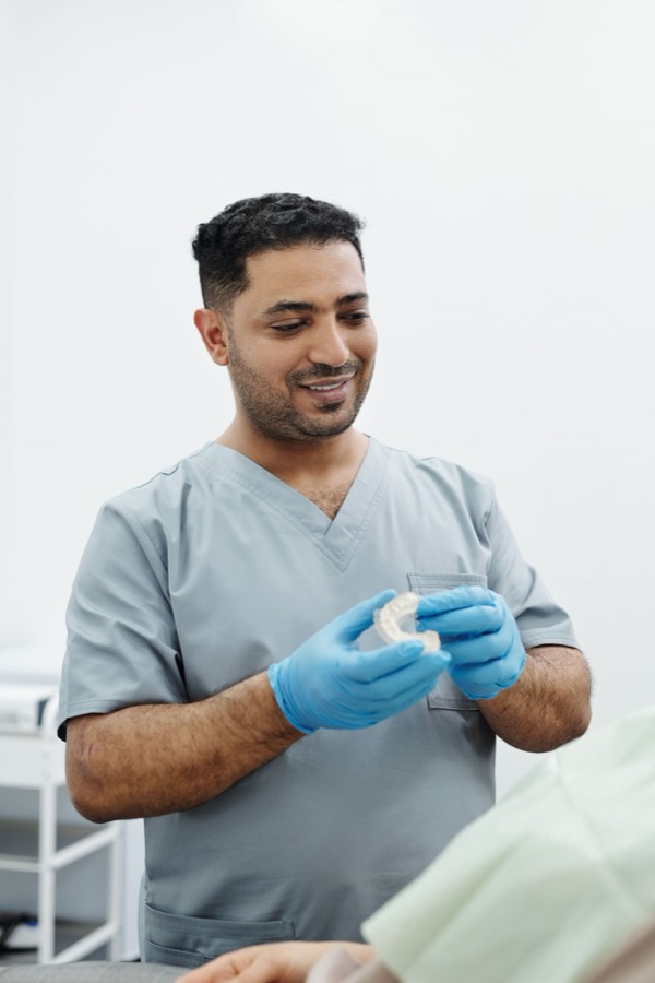 Friendly Care32 dentist holding a dental model